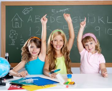 clever kids student group at school classroom raising hand as smart children